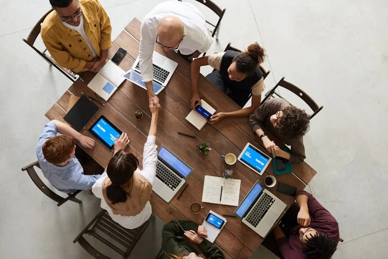Security consultancy team meeting around table with laptops