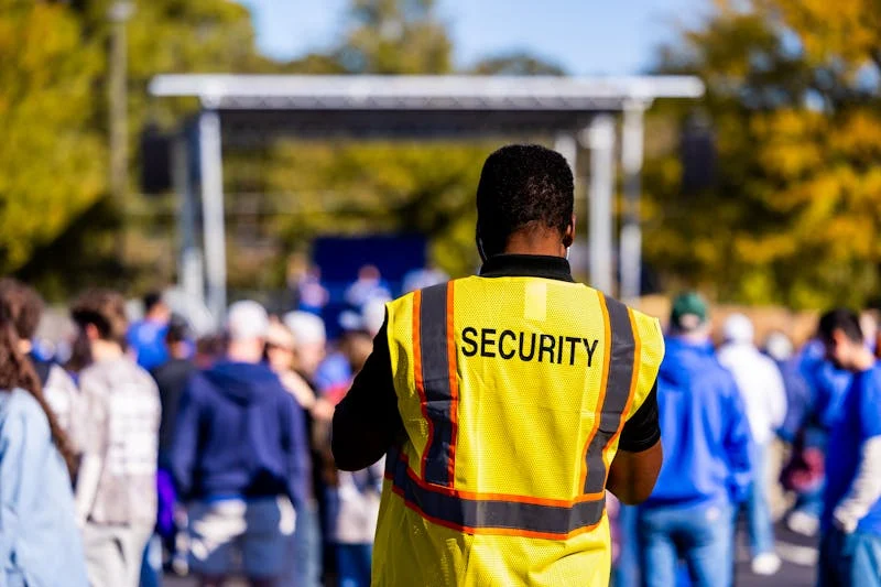Event security officer in hi-vis vest managing crowd at outdoor event